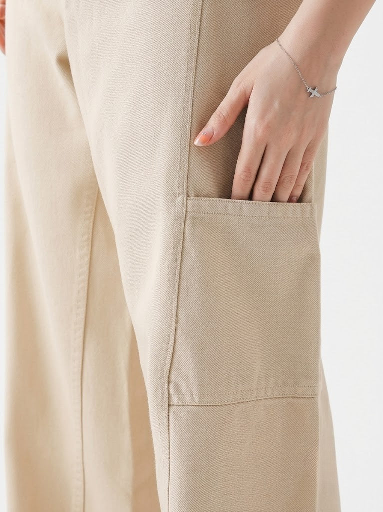 Close-up of beige pants with a hand in the pocket on a white background
