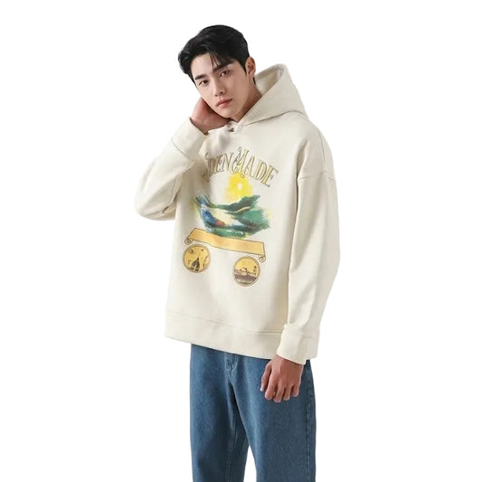 Person wearing a cream hoodie with graphic design and blue jeans against a white background