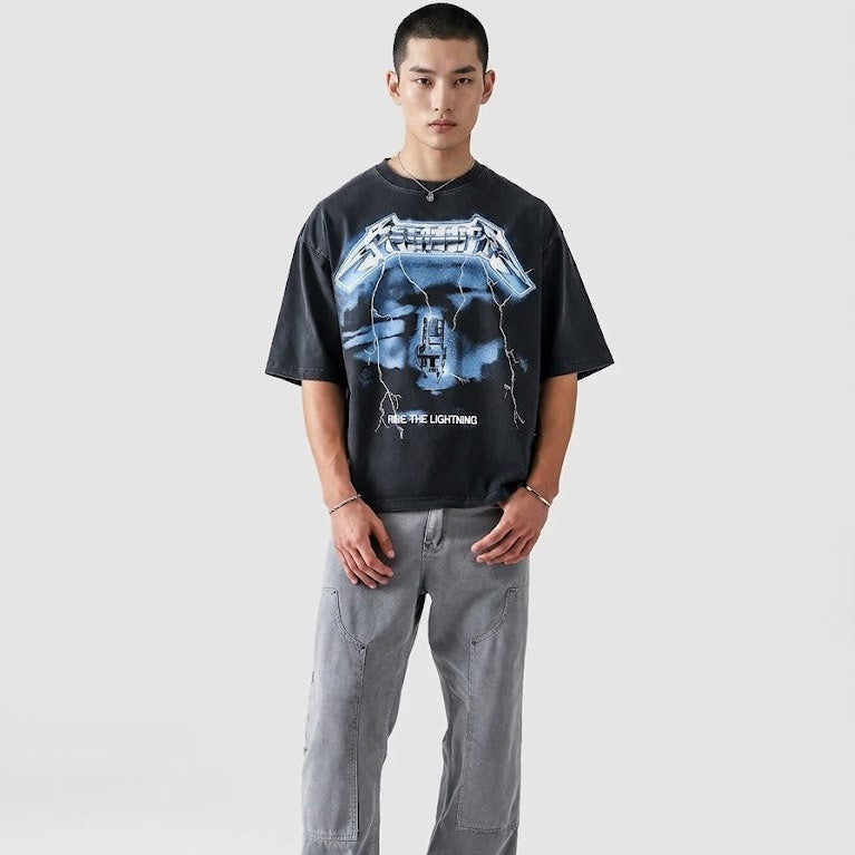 Person wearing a black graphic t-shirt and gray pants on a white background