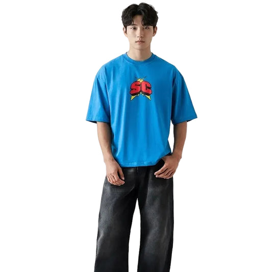 Person wearing a blue t-shirt with a logo and dark pants on a white background