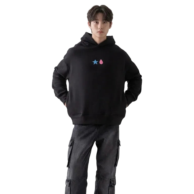 Person wearing a black hoodie with a logo and dark pants on a white background
