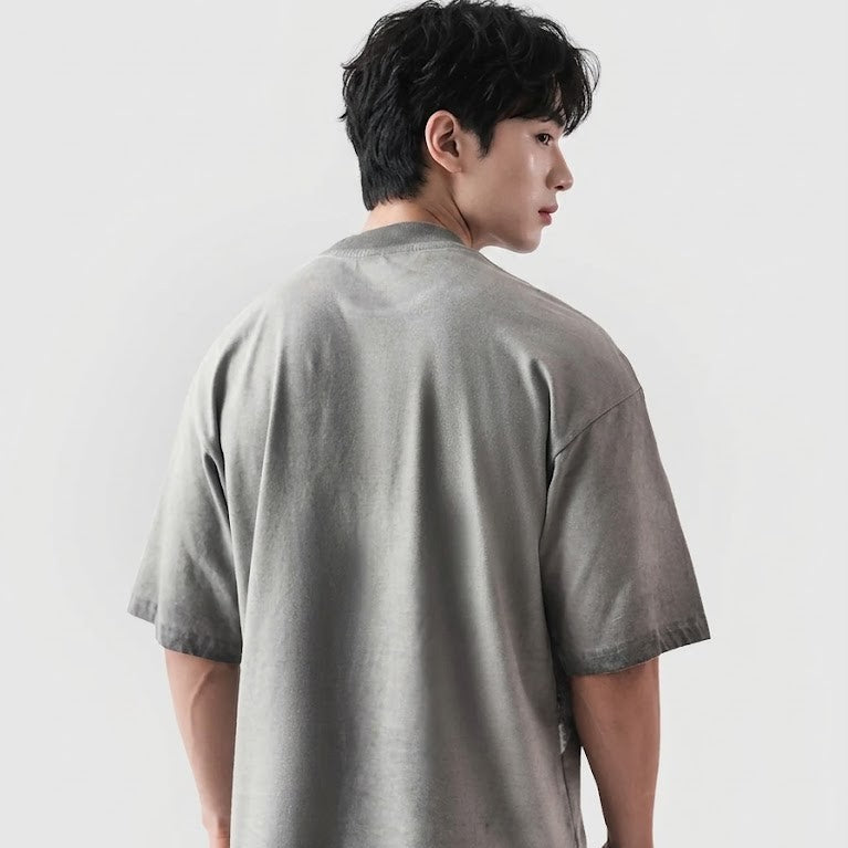 Person wearing a gray t-shirt against a white background