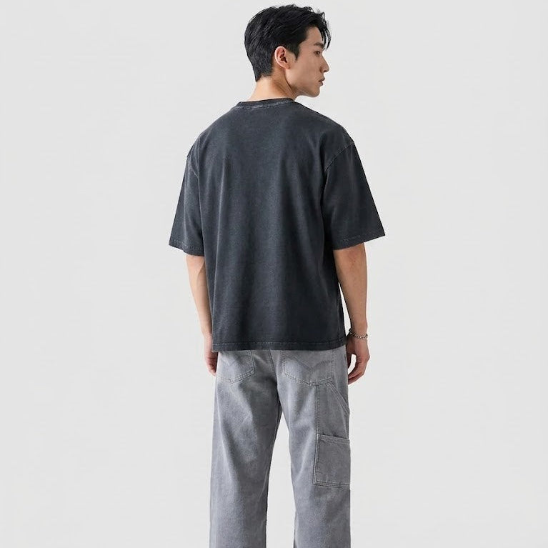 Person wearing a dark gray t-shirt and light gray pants on a white background