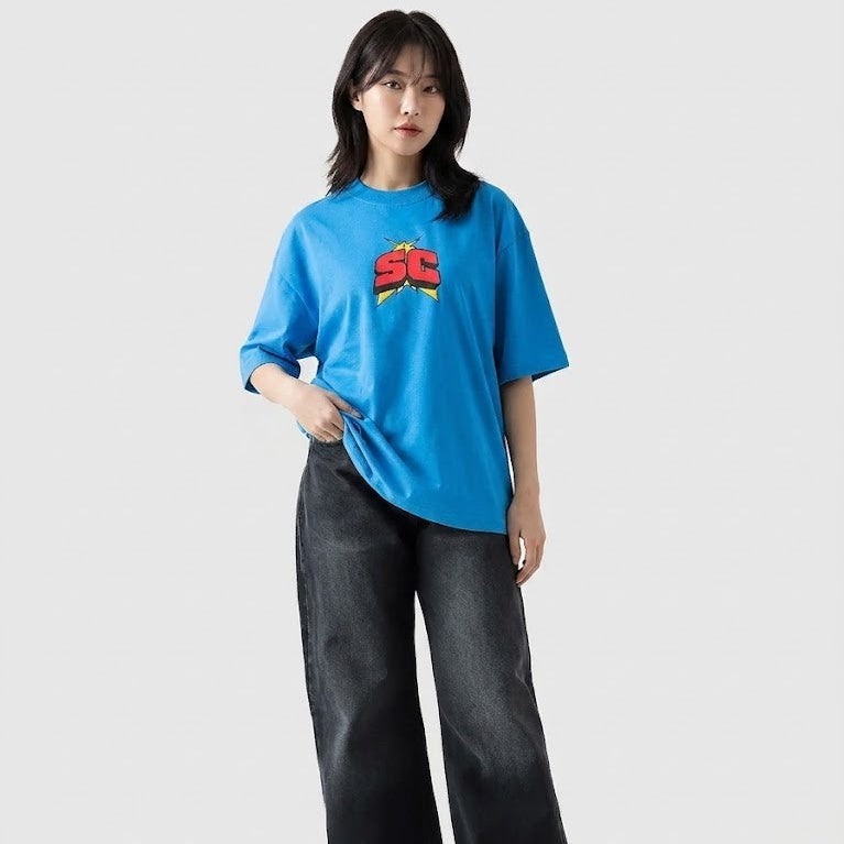 Person wearing a blue t-shirt with a logo and black pants on a white background