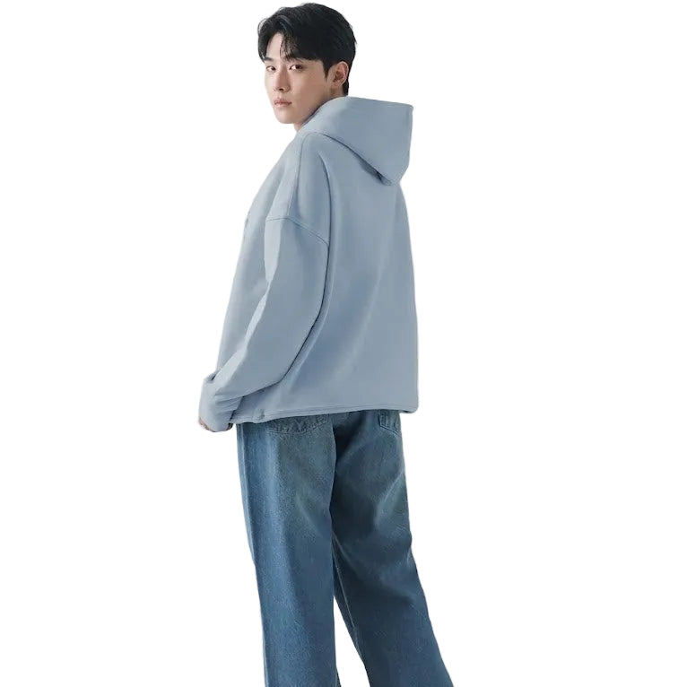 Person wearing a light blue hoodie and jeans on a white background