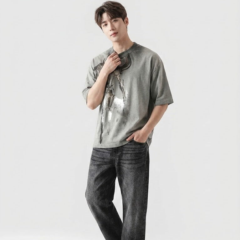 Person wearing a gray t-shirt and dark jeans on a white background