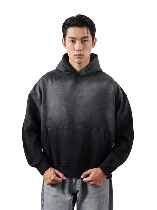 Person wearing a black hoodie against a plain background