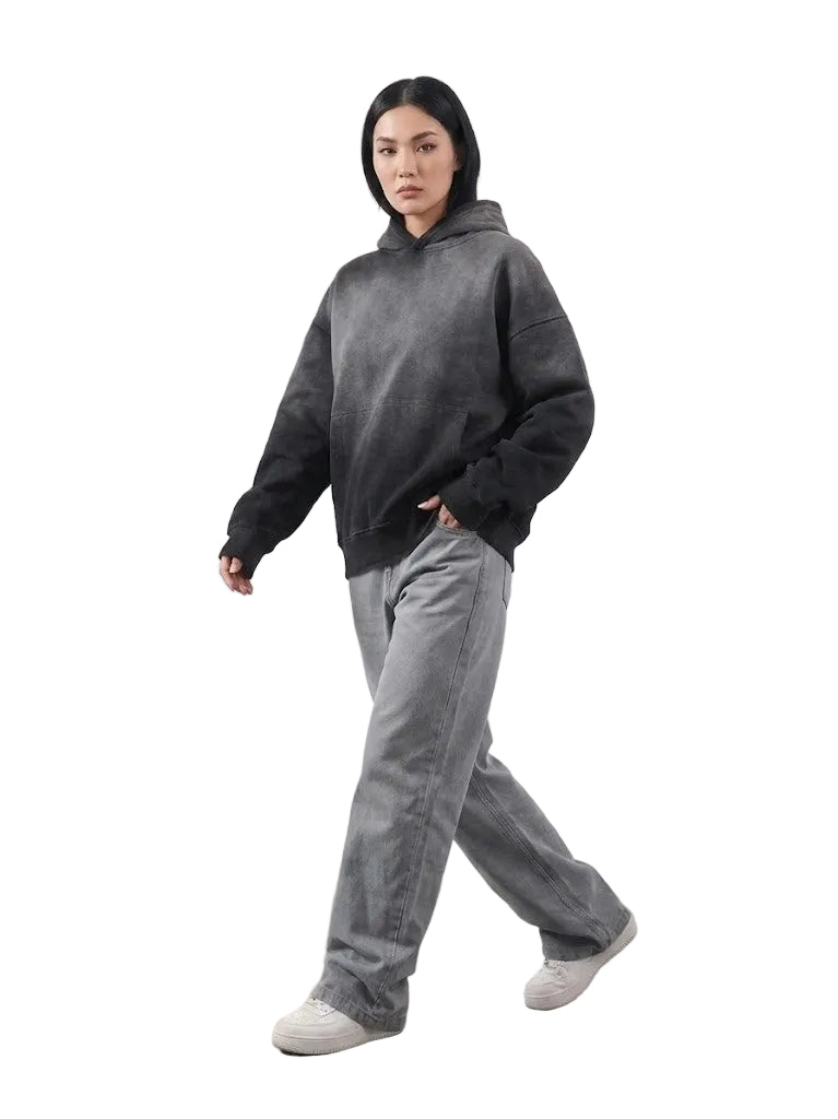 Person wearing a dark gray hoodie and light gray pants on a white background