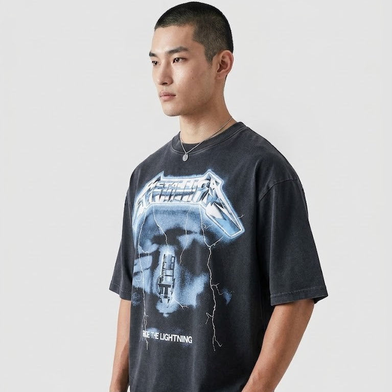 Person wearing a black t-shirt with graphic design on a plain background