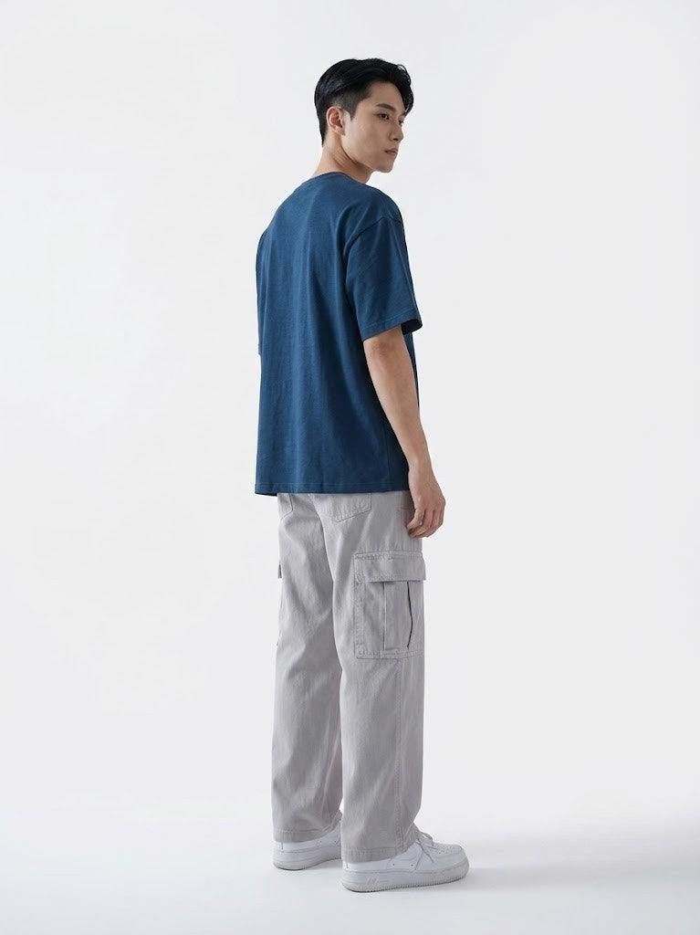 Person wearing a blue t-shirt and gray cargo pants on a white background
