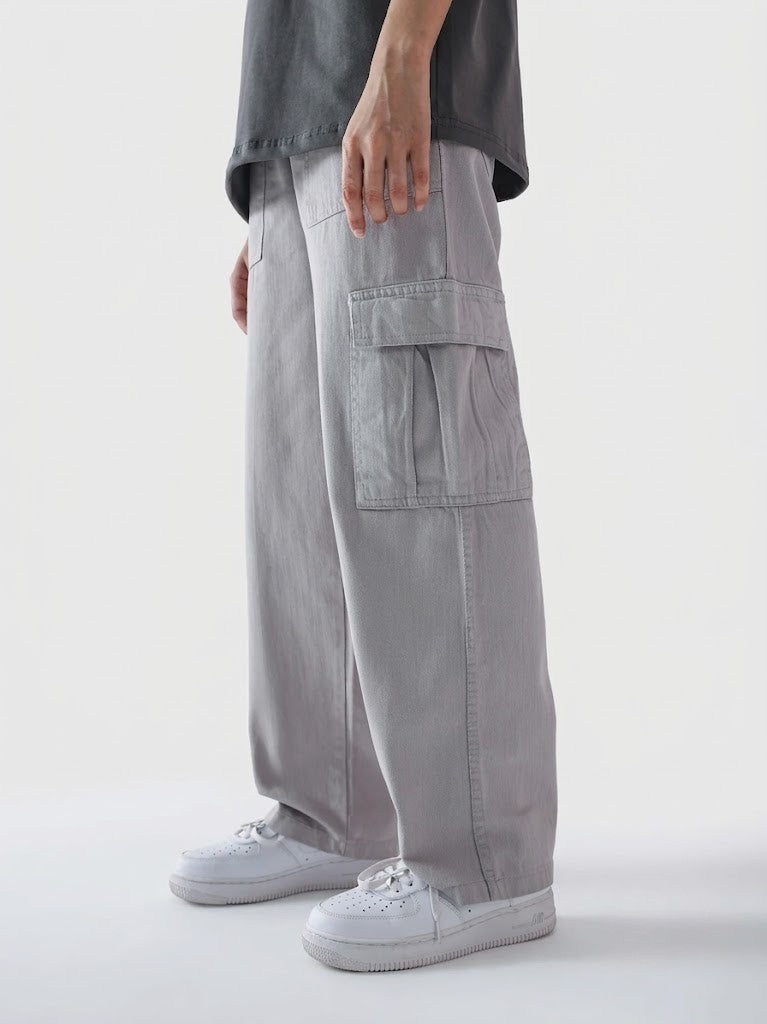 Person wearing gray cargo pants and white sneakers on a light gray background
