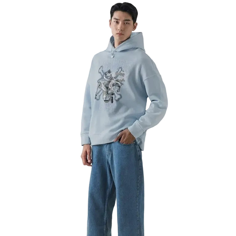 Person wearing a light blue hoodie with a graphic design and blue jeans on a white background