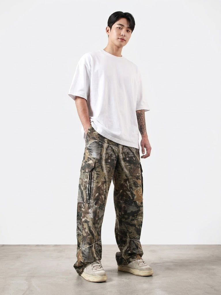 Person wearing a white t-shirt and camouflage pants on a plain background