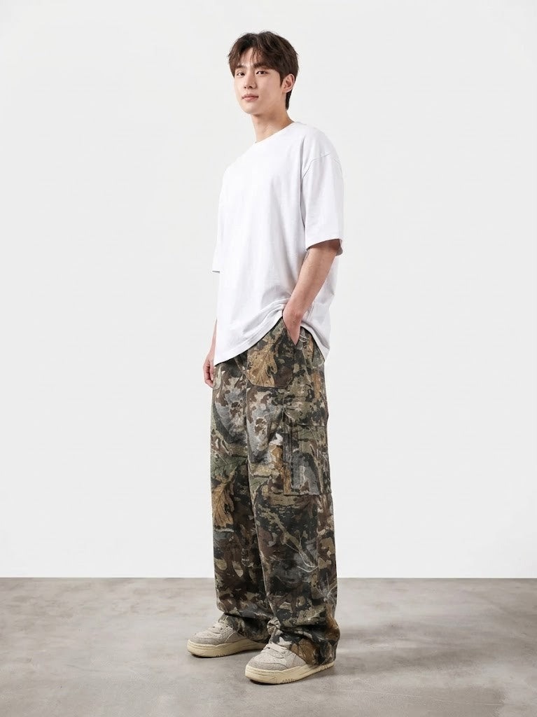 Person wearing a white t-shirt and camouflage pants on a plain background