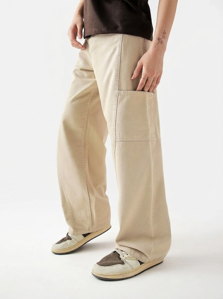 Person wearing beige wide-leg pants on a white background