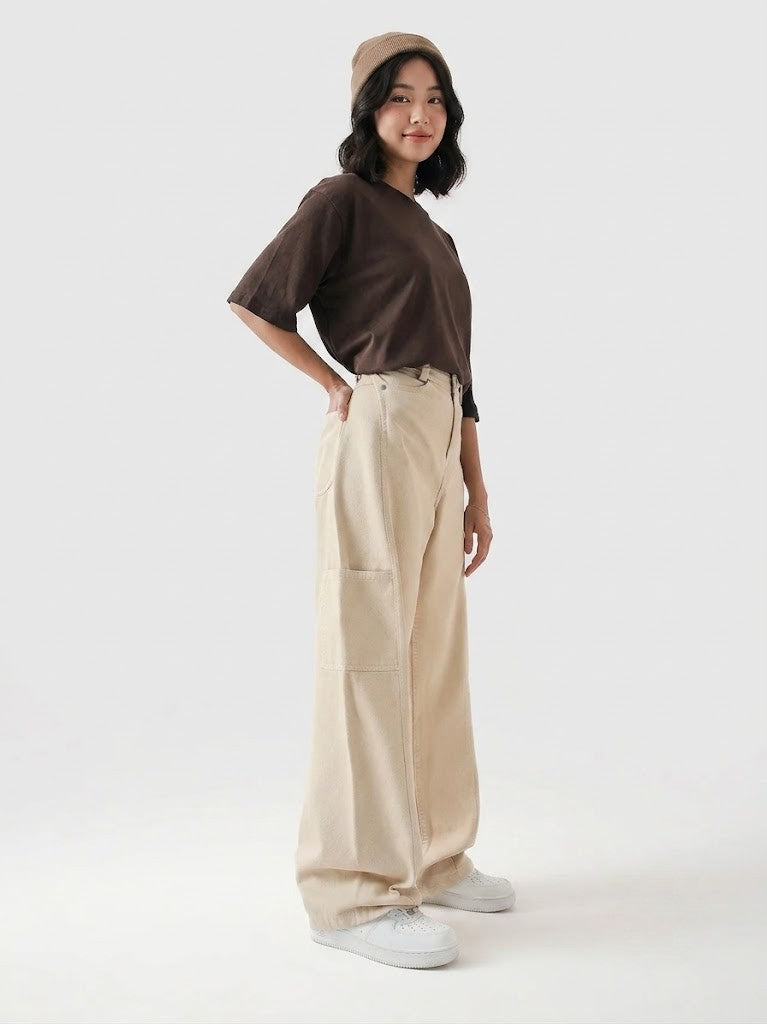 Person wearing a brown shirt, beige pants, and a beige cap on a white background