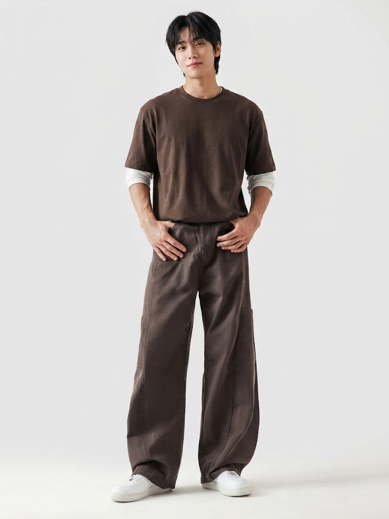 Man wearing a brown t-shirt and pants on a white background